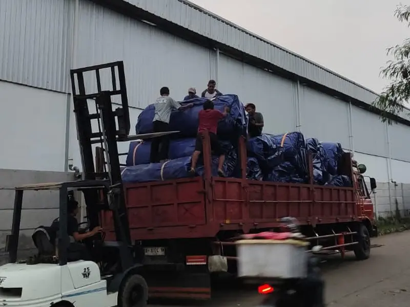 Pemuatan terpal biru YO Tarpaulin ke truk engkel dengan forklift