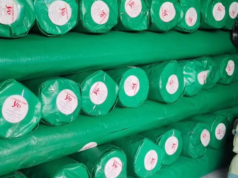 Stok roll terpal hijau berlabel Yo Nusantara Raya di gudang