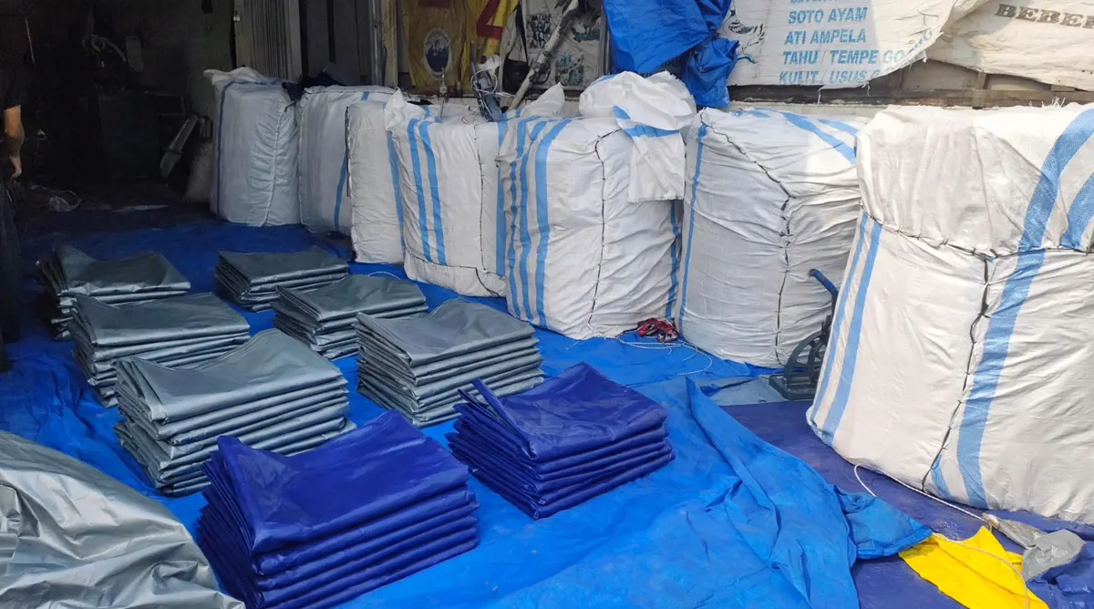 Gudang YO Tarpaulin penuh stok terpal terkemas karung dan tumpukan lembar siap kirim